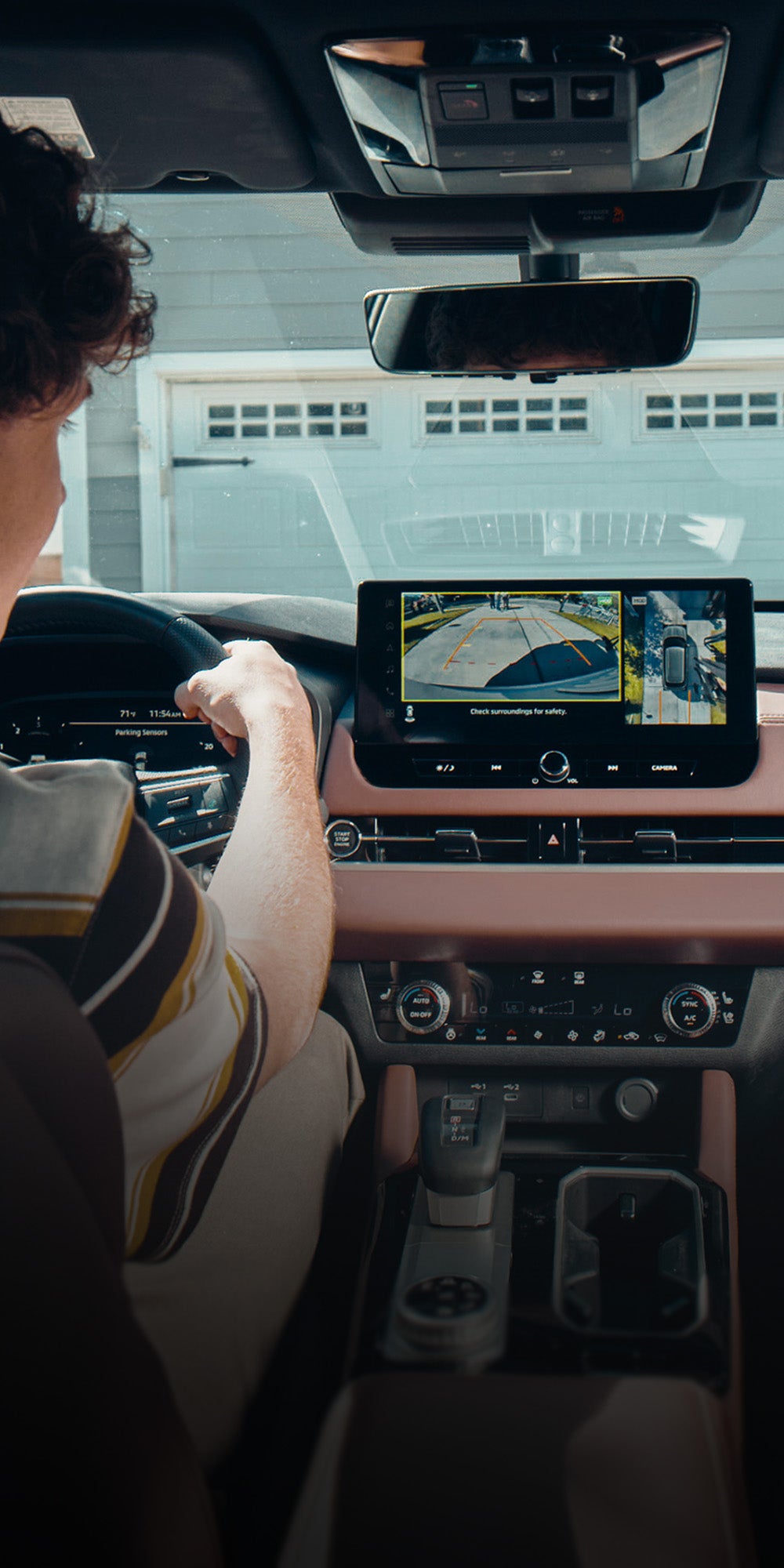 Person reversing out of a driveway in the 2026 Mitsubishi Outlander SUV using the multi view camera system